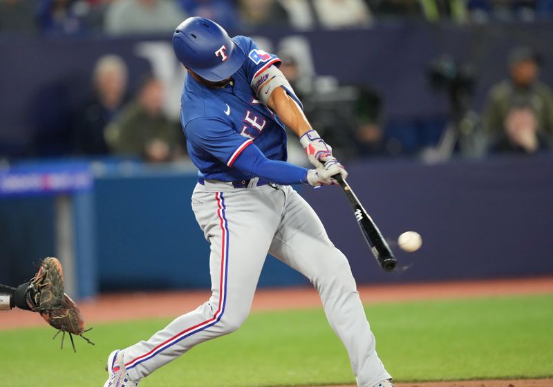 Sep 13, 2023; Toronto, Ontario, CAN; Texas Rangers second baseman Marcus Semien (2) hits a single against the Toronto Blue Jays during the ninth inning at Rogers Centre. Mandatory Credit: Nick Turchiaro-USA TODAY Sports