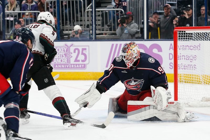 Nov 16, 2023; Columbus, Ohio, USA; Columbus Blue Jackets goalie Elvis Merzlikins (90) makes a save as Arizona Coyotes center Clayton Keller (9) looks for a rebound during the third period at Nationwide Arena. Mandatory Credit: Russell LaBounty-USA TODAY Sports