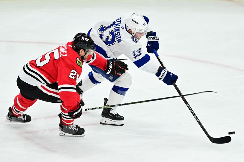 Jan 24, 2025; Chicago, Illinois, USA; Tampa Bay Lightning right wing Cam Atkinson (13) shoots the puck as Chicago Blackhawks defenseman Alec Martinez (25) defends during the third period at the United Center. Mandatory Credit: Daniel Bartel-Imagn Images