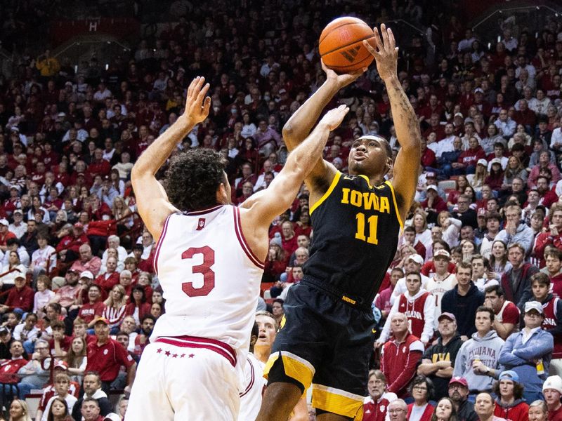 Jan 30, 2024; Bloomington, Indiana, USA; Iowa Hawkeyes guard Tony Perkins (11) shoots the ball while Indiana Hoosiers guard Anthony Leal (3) defends in the second half at Simon Skjodt Assembly Hall. Mandatory Credit: Trevor Ruszkowski-USA TODAY Sports