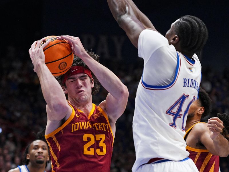 Jan 13, 2026; Lawrence, Kansas, USA; Iowa State Cyclones forward Blake Buchanan (23) grabs a rebound against Kansas Jayhawks forward Flory Bidunga (40) during the first half at Allen Fieldhouse. Mandatory Credit: Jay Biggerstaff-Imagn Images