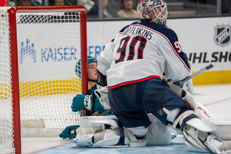 Nov 5, 2024; San Jose, California, USA;  San Jose Sharks center Macklin Celebrini (71) shot is blocked by Columbus Blue Jackets goaltender Elvis Merzlikins (90) during the second period at SAP Center at San Jose. Mandatory Credit: Neville E. Guard-Imagn Images