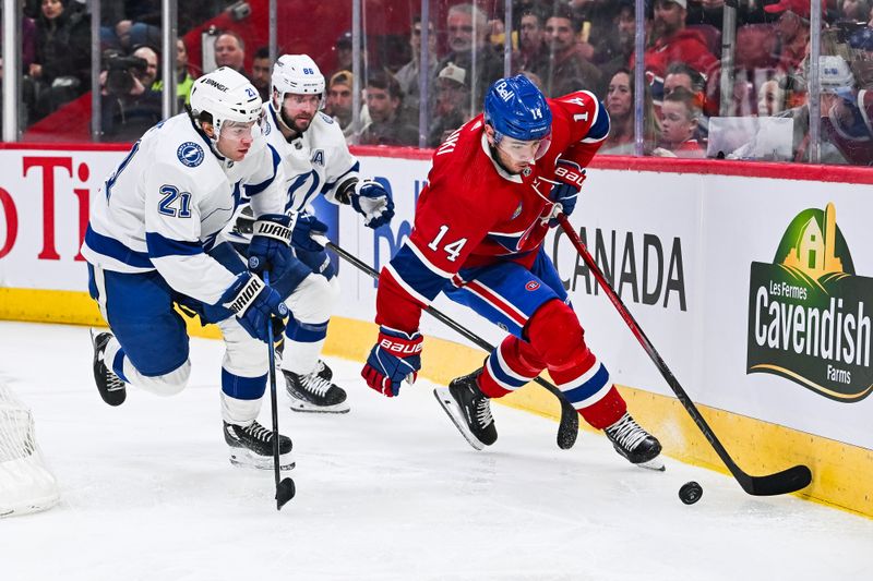 Apr 4, 2024; Montreal, Quebec, CAN; Montreal Canadiens center Nick Suzuki (14) plays the puck against Tampa Bay Lightning center Brayden Point (21) during the second period at Bell Centre. Mandatory Credit: David Kirouac-USA TODAY Sports