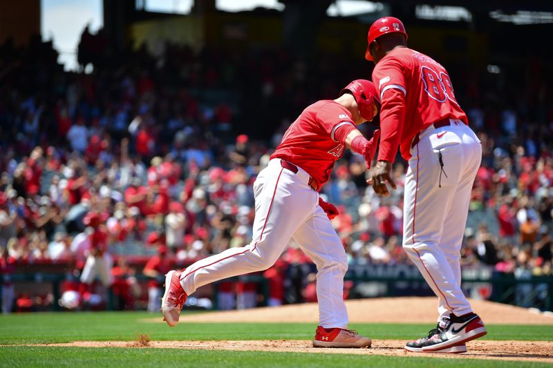 May 26, 2024; Anaheim, California, USA; Los Angeles Angels catcher Matt Thaiss (21) is greeted by first base coach Bo Porter (88) after hitting a two run home run against the Cleveland Guardians during the fifth inning at Angel Stadium. Mandatory Credit: Gary A. Vasquez-USA TODAY Sports