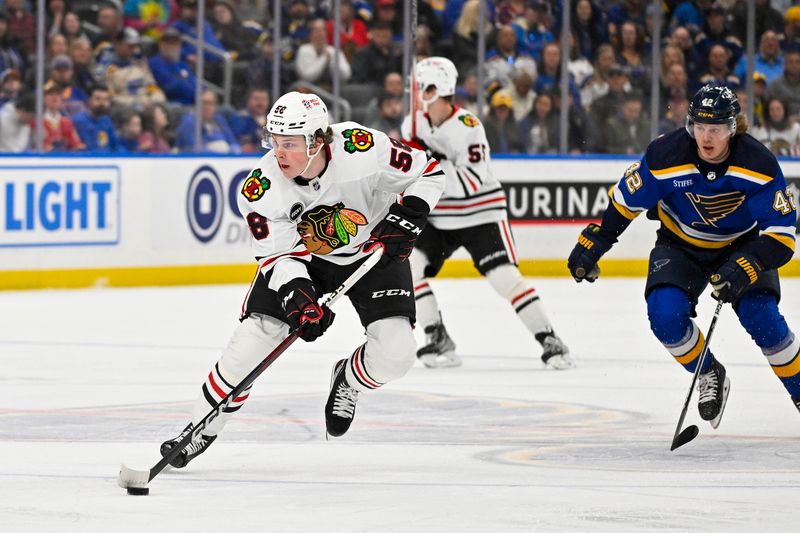 Apr 10, 2024; St. Louis, Missouri, USA;  Chicago Blackhawks right wing MacKenzie Entwistle (58) controls the puck against the St. Louis Blues during the first period at Enterprise Center. Mandatory Credit: Jeff Curry-USA TODAY Sports