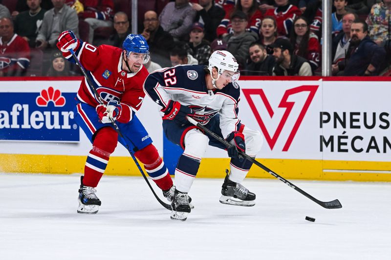 Mar 12, 2024; Montreal, Quebec, CAN; Columbus Blue Jackets defenseman Jake Bean (22) defends the puck against Montreal Canadiens left wing Tanner Pearson (70) during the first period at Bell Centre. Mandatory Credit: David Kirouac-USA TODAY Sports