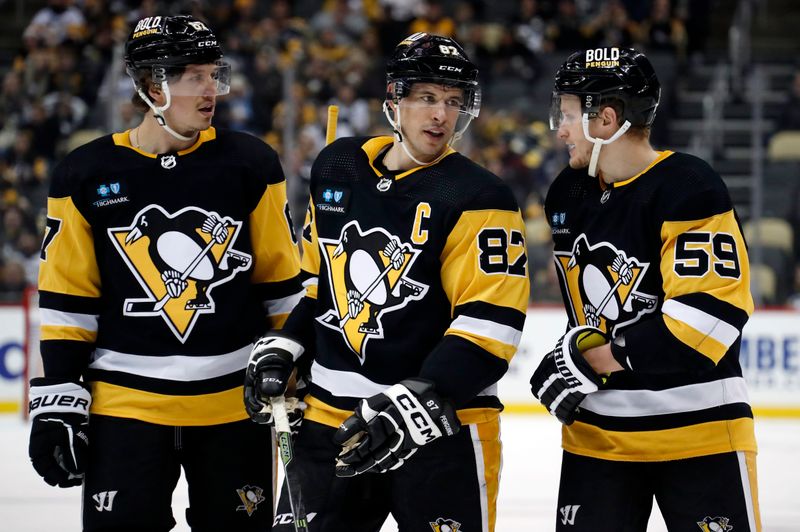 Jan 13, 2023; Pittsburgh, Pennsylvania, USA; Pittsburgh Penguins right wing Rickard Rakell (67) and center Sidney Crosby (87) and left wing Jake Guentzel (59) talk before a face-off against the Winnipeg Jets during the third period at PPG Paints Arena. Mandatory Credit: Charles LeClaire-USA TODAY Sports