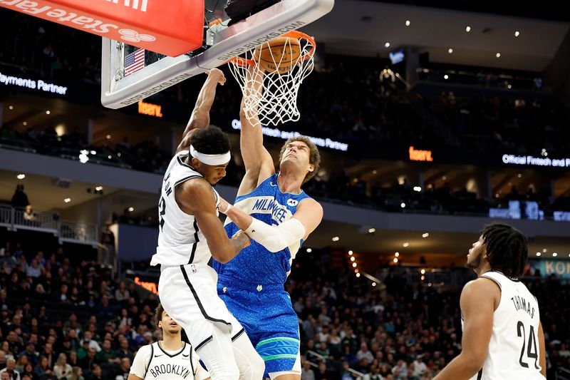 MILWAUKEE, WISCONSIN - MARCH 21: Brook Lopez #11 of the Milwaukee Bucks scores on a dunk over Nic Claxton #33 of the Brooklyn Nets during the first half of the game at Fiserv Forum on March 21, 2024 in Milwaukee, Wisconsin. NOTE TO USER: User expressly acknowledges and agrees that, by downloading and or using this photograph, User is consenting to the terms and conditions of the Getty Images License Agreement. (Photo by John Fisher/Getty Images)