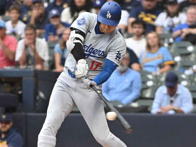 Aug 14, 2024; Milwaukee, Wisconsin, USA; Los Angeles Dodgers two-way player Shohei Ohtani (17) gets a hit against the Milwaukee Brewers in the first inning at American Family Field. Mandatory Credit: Michael McLoone-USA TODAY Sports