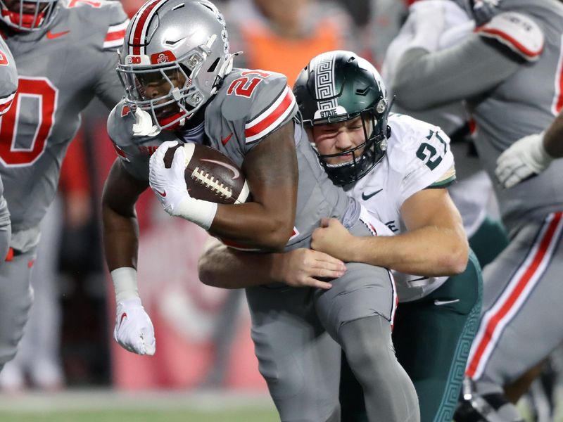 Nov 11, 2023; Columbus, Ohio, USA; Ohio State Buckeyes running back Evan Pryor (21) runs the ball as Michigan State Spartans linebacker Cal Haladay (27) makes the tackle during the fourth quarter at Ohio Stadium. Mandatory Credit: Joseph Maiorana-USA TODAY Sports