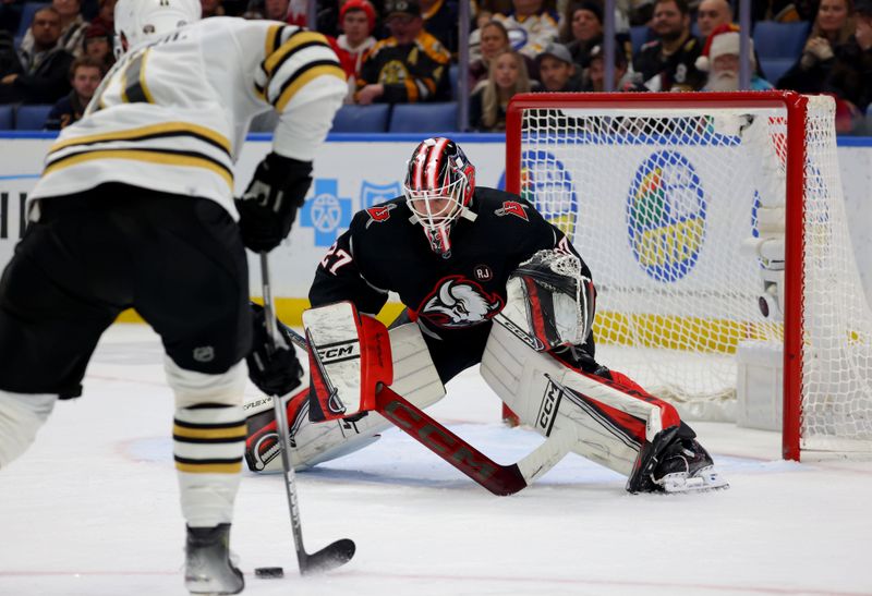 Dec 27, 2023; Buffalo, New York, USA;  Boston Bruins center Trent Frederic (11) looks to take a shot on Buffalo Sabres goaltender Devon Levi (27) during the third period at KeyBank Center. Mandatory Credit: Timothy T. Ludwig-USA TODAY Sports