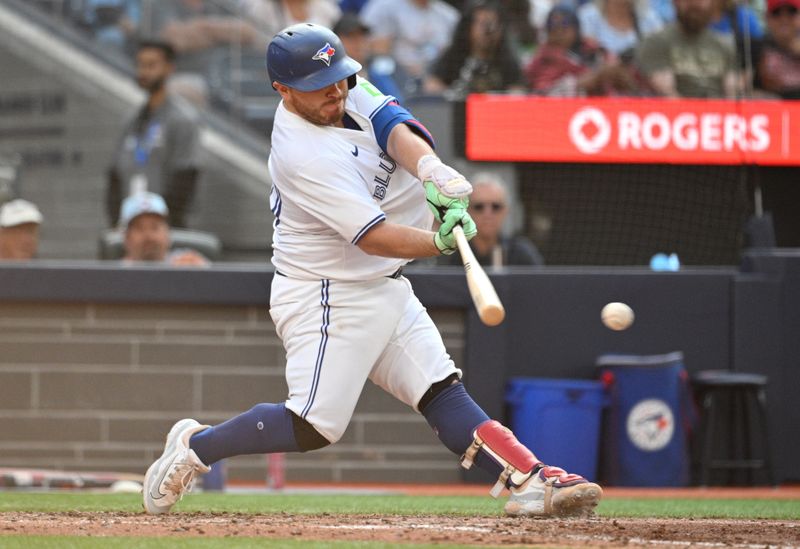 Sep 14, 2024; Toronto, Ontario, CAN;  Toronto Blue Jays catcher Alejandro Kirk (30) hits an RBI single against the St. Louis Cardinals in the seventh inning at Rogers Centre. Mandatory Credit: Dan Hamilton-Imagn Images