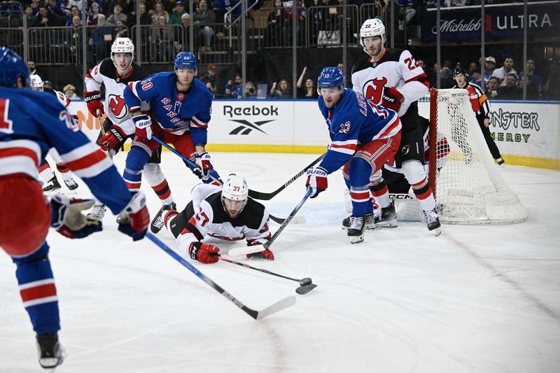 Dec 2, 2024; New York, New York, USA;  New Jersey Devils center Justin Dowling (37) plays the puck in front of New York Rangers left wing Alexis Lafrenière (13) during the second period at Madison Square Garden. Mandatory Credit: Dennis Schneidler-Imagn Images