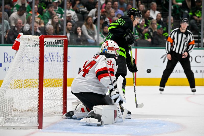 Mar 14, 2024; Dallas, Texas, USA; New Jersey Devils goaltender Jake Allen (34) and Dallas Stars left wing Jason Robertson (21) track the puck in the air during the second period at the American Airlines Center. Mandatory Credit: Jerome Miron-USA TODAY Sports