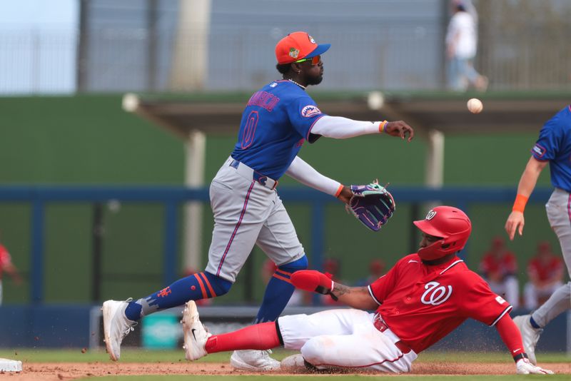 Mar 5, 2026; West Palm Beach, Florida, USA; New York Mets third baseman Ronny Mauricio (0) turns a double play against the Washington Nationals during the fourth inning at CACTI Park of the Palm Beaches. Mandatory Credit: Sam Navarro-Imagn Images