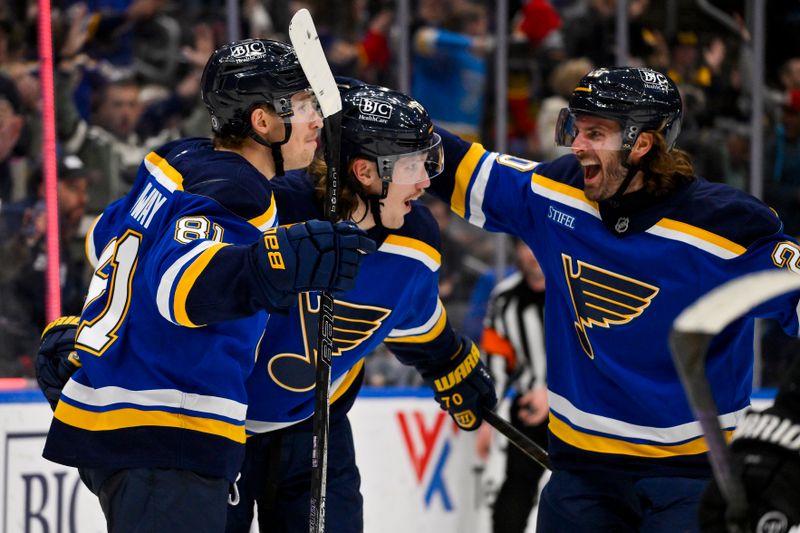 Nov 12, 2024; St. Louis, Missouri, USA;  St. Louis Blues center Oskar Sundqvist (70) is congratulated by center Dylan Holloway (81) and left wing Brandon Saad (20) after scoring against the Boston Bruins during the second period at Enterprise Center. Mandatory Credit: Jeff Curry-Imagn Images