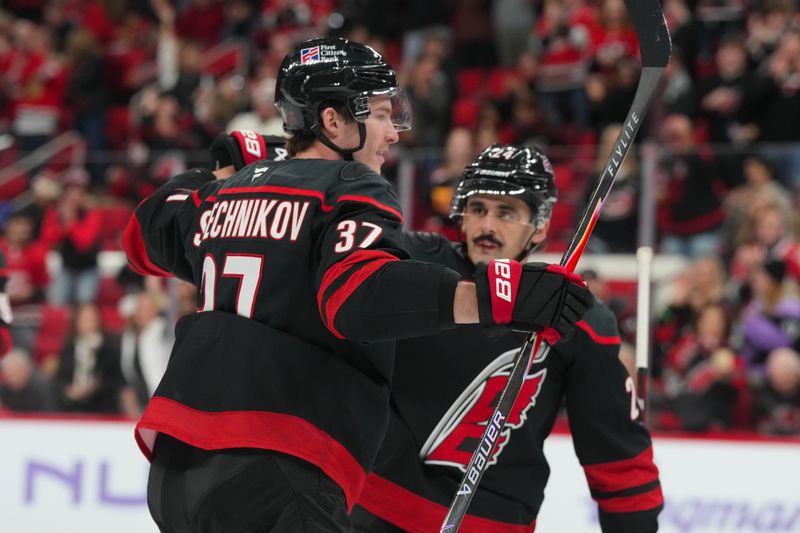 Nov 14, 2025; Raleigh, North Carolina, USA;  Carolina Hurricanes right wing Andrei Svechnikov (37) celebrates his goal with center Seth Jarvis (24) against the Vancouver Canucks during the first period at Lenovo Center. Mandatory Credit: James Guillory-Imagn Images