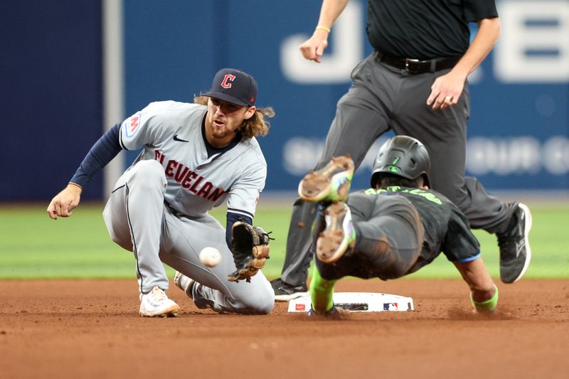 Jul 13, 2024; St. Petersburg, Florida, USA; Tampa Bay Rays shortstop Jose Caballero (7) is caught stealing by Cleveland Guardians shortstop Daniel Schneemann (10) in the seventh inning at Tropicana Field. Mandatory Credit: Nathan Ray Seebeck-USA TODAY Sports