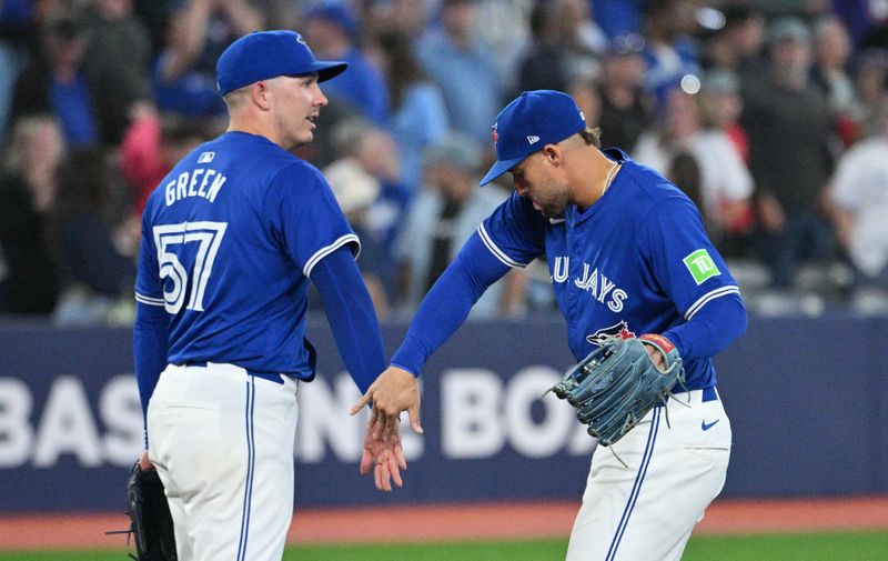 Jul 2, 2024; Toronto, Ontario, CAN;   Toronto Blue Jays relief pitcher Chad Green (57) and right fielder George Springer (4) celebrate a win over the Houston Astros at Rogers Centre. Mandatory Credit: Dan Hamilton-USA TODAY Sports