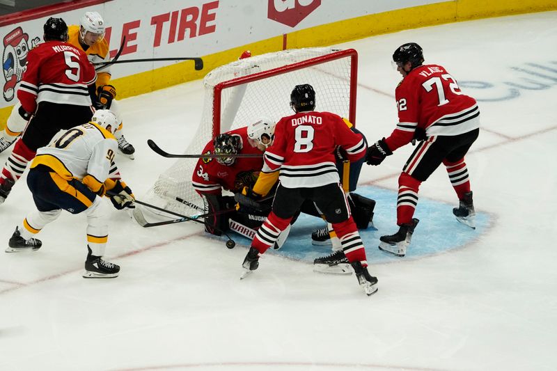 Oct 25, 2024; Chicago, Illinois, USA; Chicago Blackhawks goaltender Petr Mrazek (34) makes a save on Nashville Predators center Ryan O'Reilly (90) during the second period at the United Center. Mandatory Credit: David Banks-Imagn Images