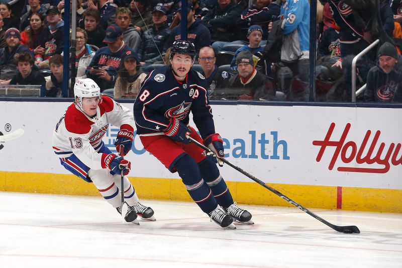 Nov 27, 2024; Columbus, Ohio, USA; Columbus Blue Jackets defenseman Zach Werenski (8) controls the puck as Montreal Canadiens right wing Cole Caufield (13) defends during the first period at Nationwide Arena. Mandatory Credit: Russell LaBounty-Imagn Images