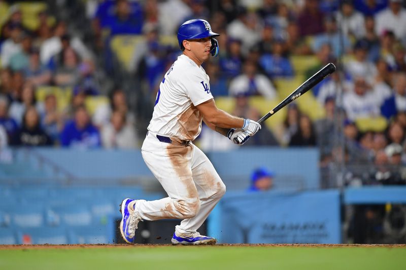 Aug 29, 2024; Los Angeles, California, USA; Los Angeles Dodgers catcher Austin Barnes (15) hits a single against the Baltimore Orioles during the eighth inning at Dodger Stadium. Mandatory Credit: Gary A. Vasquez-USA TODAY Sports